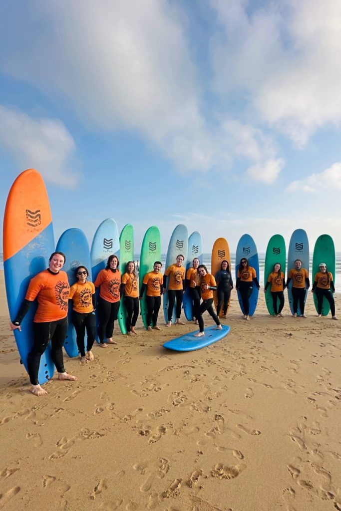 University surf trip Portugal — students in wetsuits at Atlantic Ocean